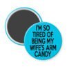 Blue magnet with text 'I'm so tired of being my wife's arm candy' printed in black.