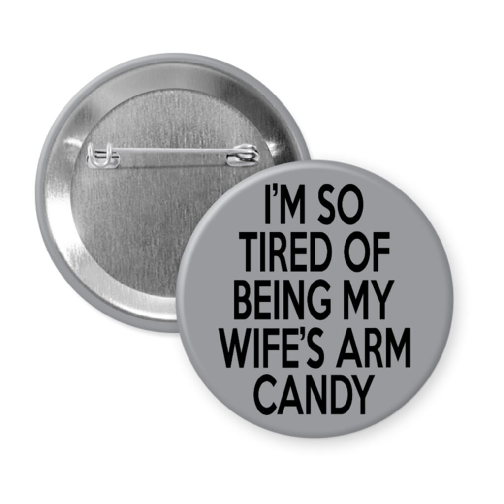 Grey pinback button with text 'I'm so tired of being my wife's arm candy' printed in black.