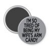 Grey magnet with text 'I'm so tired of being my wife's arm candy' printed in black.