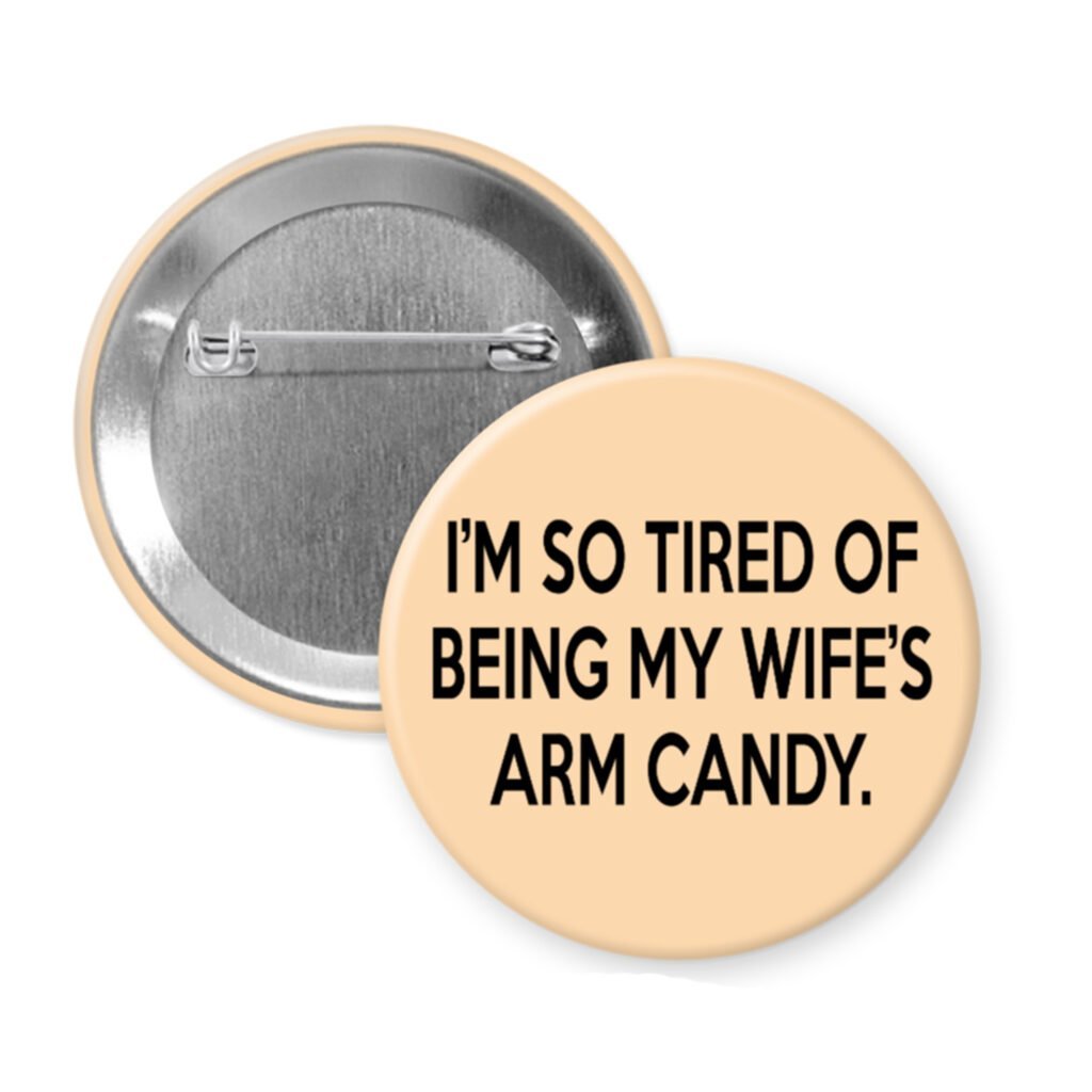 Peachy button that says "I'm so tired of being my wife's arm candy."