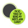 Green magnet with text 'I'm so tired of being my wife's arm candy' printed in black.