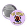Button badge with 'Be Kind of a Bitch' text and colorful flower design on a purple background.