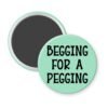 Green magnet with the text 'Begging for a pegging' printed in black.