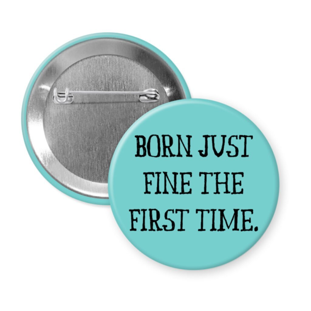Blue pinback button with the text 'Born just fine the first time.' printed in black.