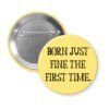 Yellow pinback button with the text 'Born just fine the first time.' printed in black.