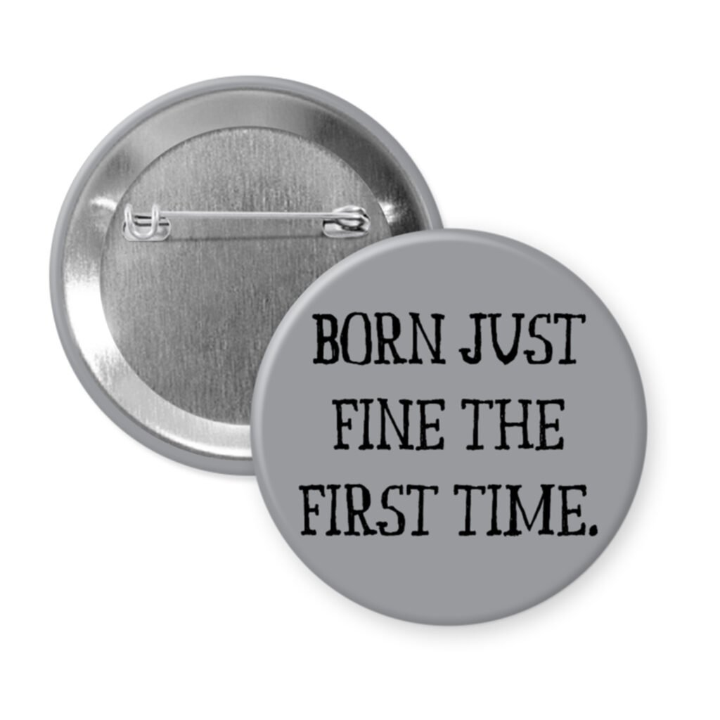 Grey pinback button with the text 'Born just fine the first time.' printed in black.