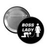 Black pinback button with graphic of collared and leashed man on his hands and knees being led by a woman and the words Boss lady.