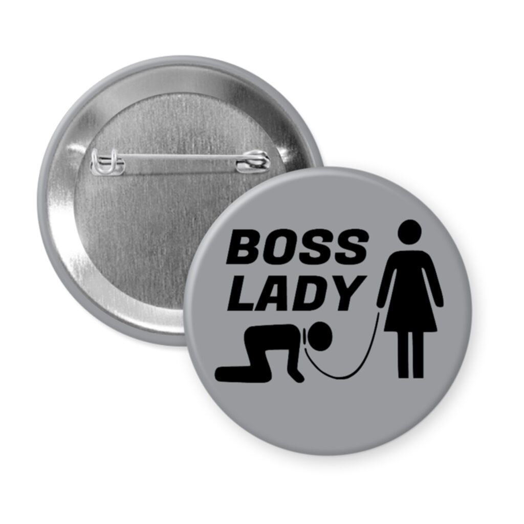 Grey pinback button with a graphic of a collared and leashed man on hands and knees, a woman figure holding the leash with the text 'BOSS LADY' printed in black.