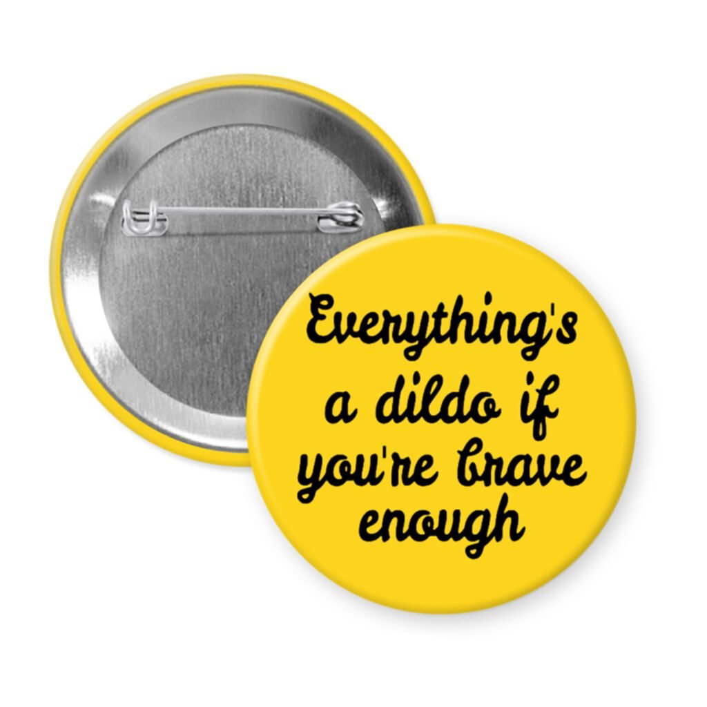 Yellow pinback button with the text 'Everything's a dildo if you're brave enough' printed in black.