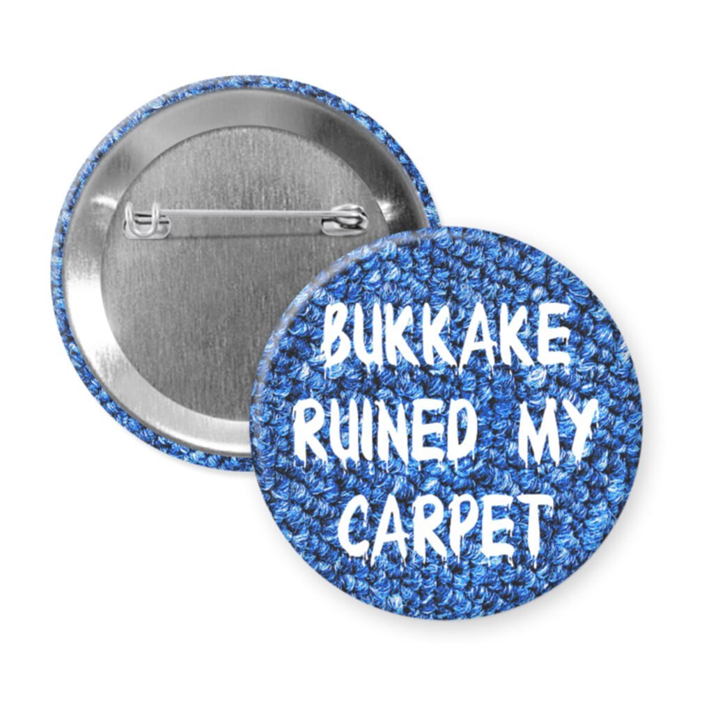 Blue carpet print pinback button with the text 'Bukkake ruined my carpet' in white drippy font.