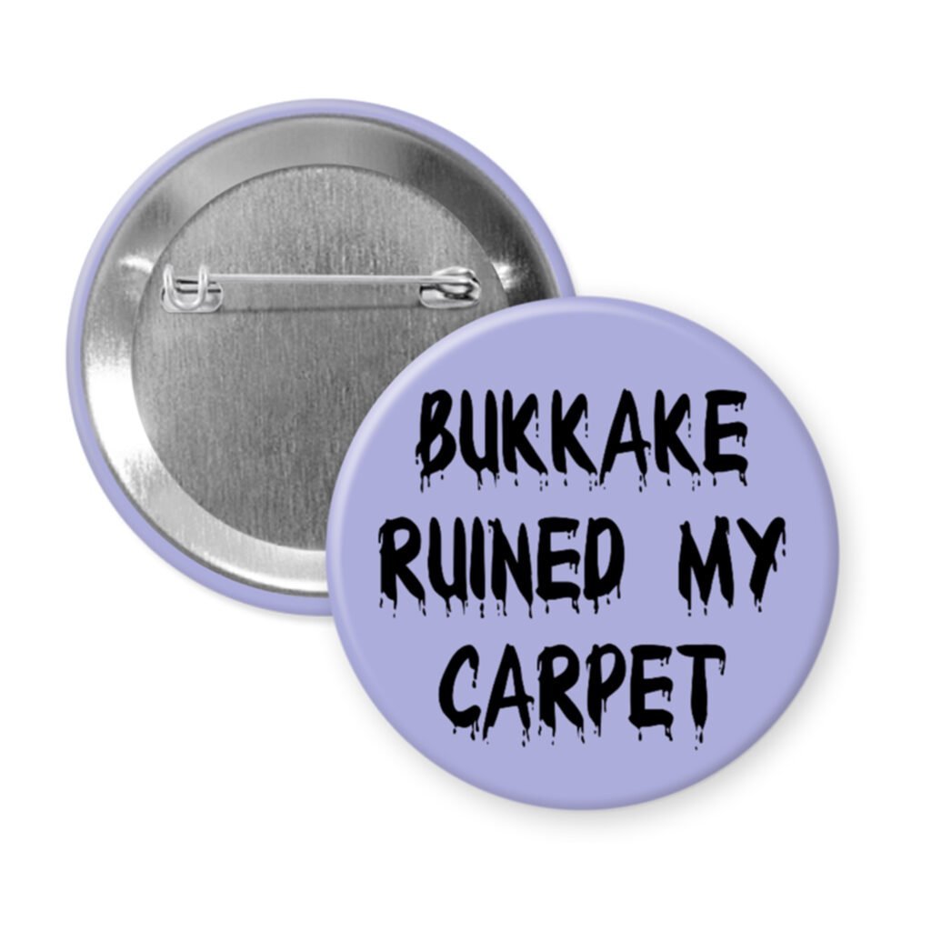Purple pinback button with the text 'Bukkake ruined my carpet' in black drippy font.