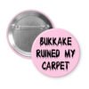 Pink pinback button with the text 'Bukkake ruined my carpet' in black drippy font.