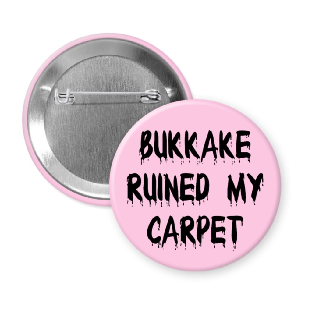 Pink pinback button with the text 'Bukkake ruined my carpet' in black drippy font.