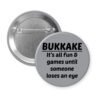 Grey pinback button with the text 'Bukkake- It's all fun & games until someone loses an eye' printed in black.