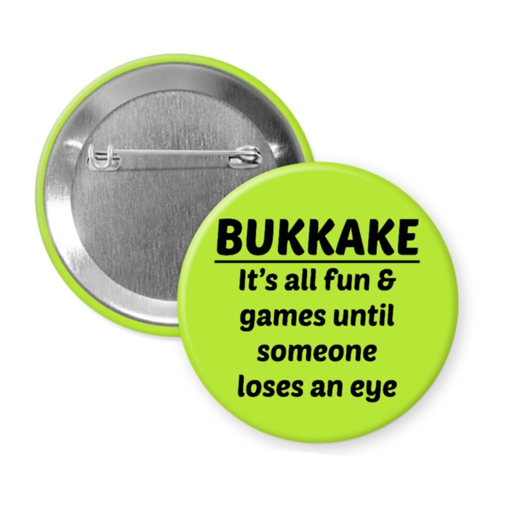 Green pinback button with the text 'Bukkake- It's all fun & games until someone loses an eye' printed in black.