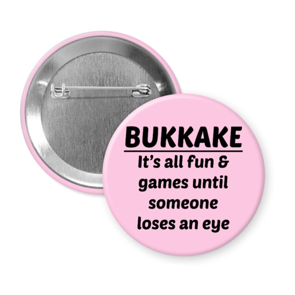 Pink pinback button with the text 'Bukkake- It's all fun & games until someone loses an eye' printed in black.