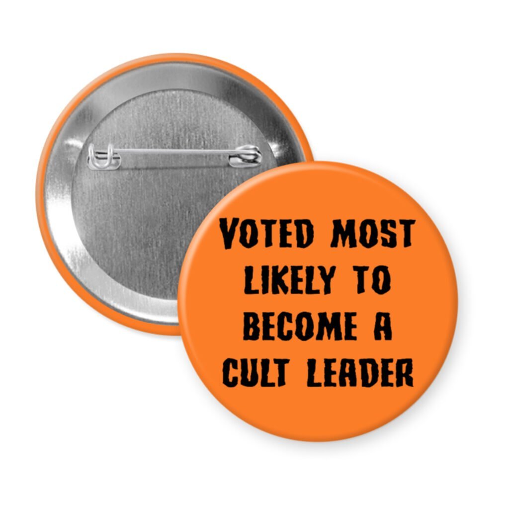 Orange pinback button with the text 'Voted most likely to become a cult leader' printed in black.