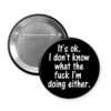 Black button badge with text 'It's ok. I don't know what the fuck I'm doing either.' on a white background