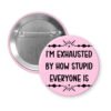 Pink pinback button with text 'I'm exhausted by how stupid everyone is' printed in black.