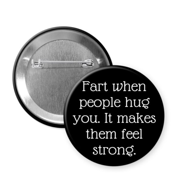 Black button badge with humorous text 'Fart when people hug you. It makes them feel strong.' on a white background