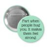 Mint green pinback button with the text 'Fart when people hug you. It makes them feel strong.' printed in black.