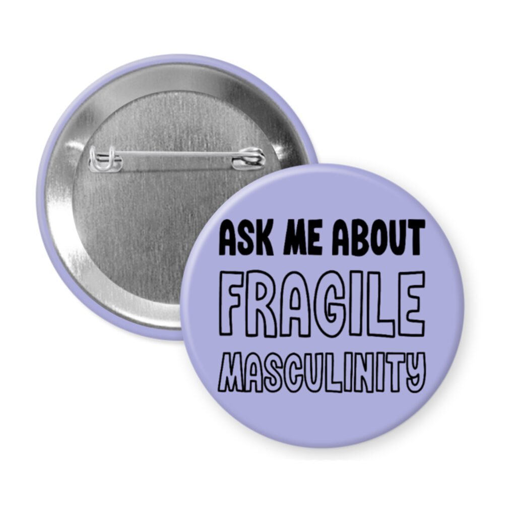 Purple pinback button with the text 'Ask me about fragile masculinity' printed in black.