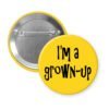 Yellow pinback button with the text 'I'm a grown-up' printed in black.