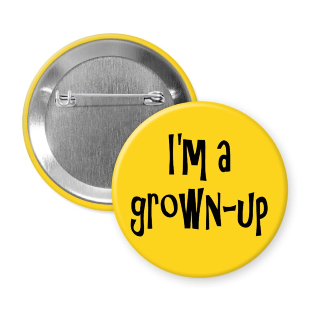 Yellow pinback button with the text 'I'm a grown-up' printed in black.