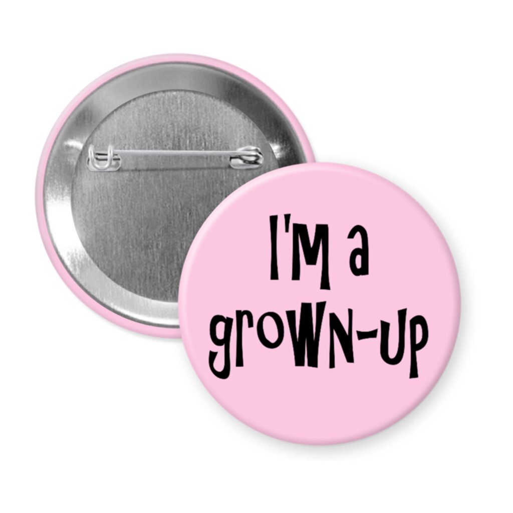 Pink pinback button with the text 'I'm a grown-up' printed in black.