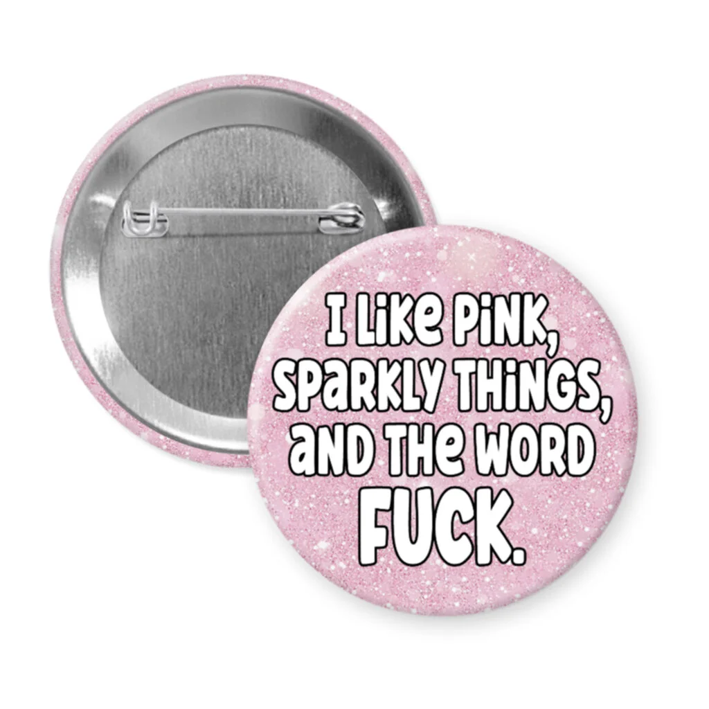 Pinback button with a printed pink glitter background and the text ' I like pink, sparkly things, and the word fuck' printed on it.