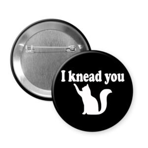 Button badge with 'I knead you' text and cat illustration on a black background