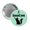 Green pinback button with silhouette of a cat and the text 'I knead you.'