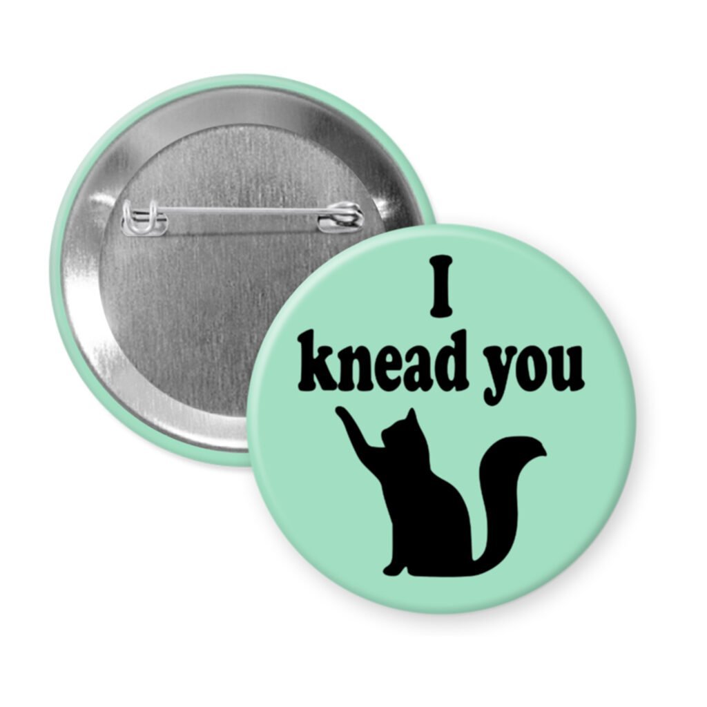 Green pinback button with silhouette of a cat and the text 'I knead you.'