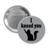 Grey pinback button with silhouette of a cat and the text 'I knead you.'