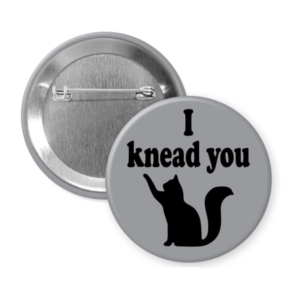 Grey pinback button with silhouette of a cat and the text 'I knead you.'