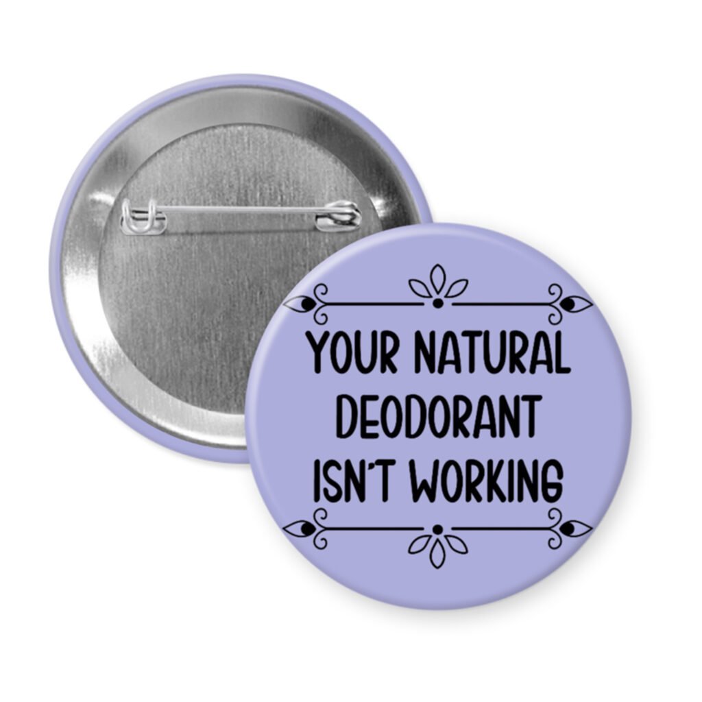 Purple pinback button with the text 'Your natural deodorant isn't working' printed in black.