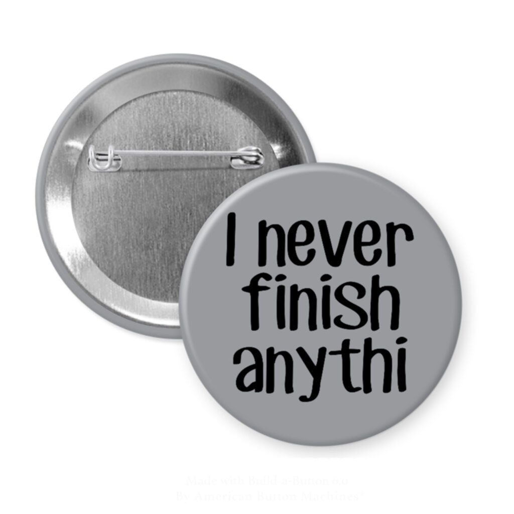 Grey pinback button with the text 'I never finish anythi" printed in black.