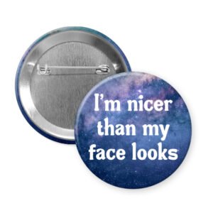 Galaxy print button that says "I'm nicer than my face looks"