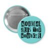 Blue pinback button with the text "Normal gets you nowhere" printed in black stencil graffiti font.