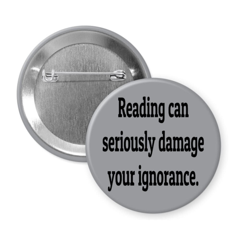 Grey pinback button with the text 'Reading can seriously damage your ignorance.' printed in black.