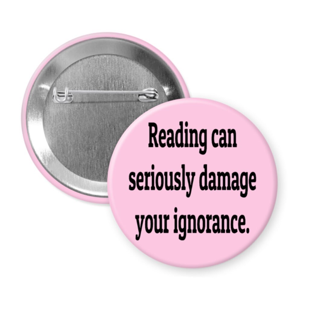 Pink pinback button with the text 'Reading can seriously damage your ignorance.' printed in black.