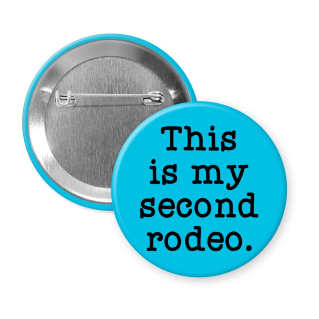 Blue pinback button with the text 'This is my second rodeo.' printed in black.