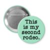 Mint green pinback button with the text 'This is my second rodeo.' printed in black.