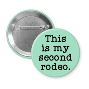 Mint green pinback button with the text 'This is my second rodeo.' printed in black.