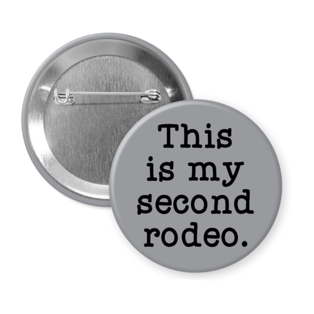 Grey pinback button with the text 'This is my second rodeo.' printed in black.