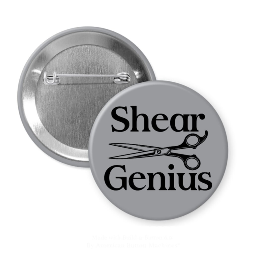 Grey pinback button with an image of haircutting shears and the text 'Shear Genius' printed in black.