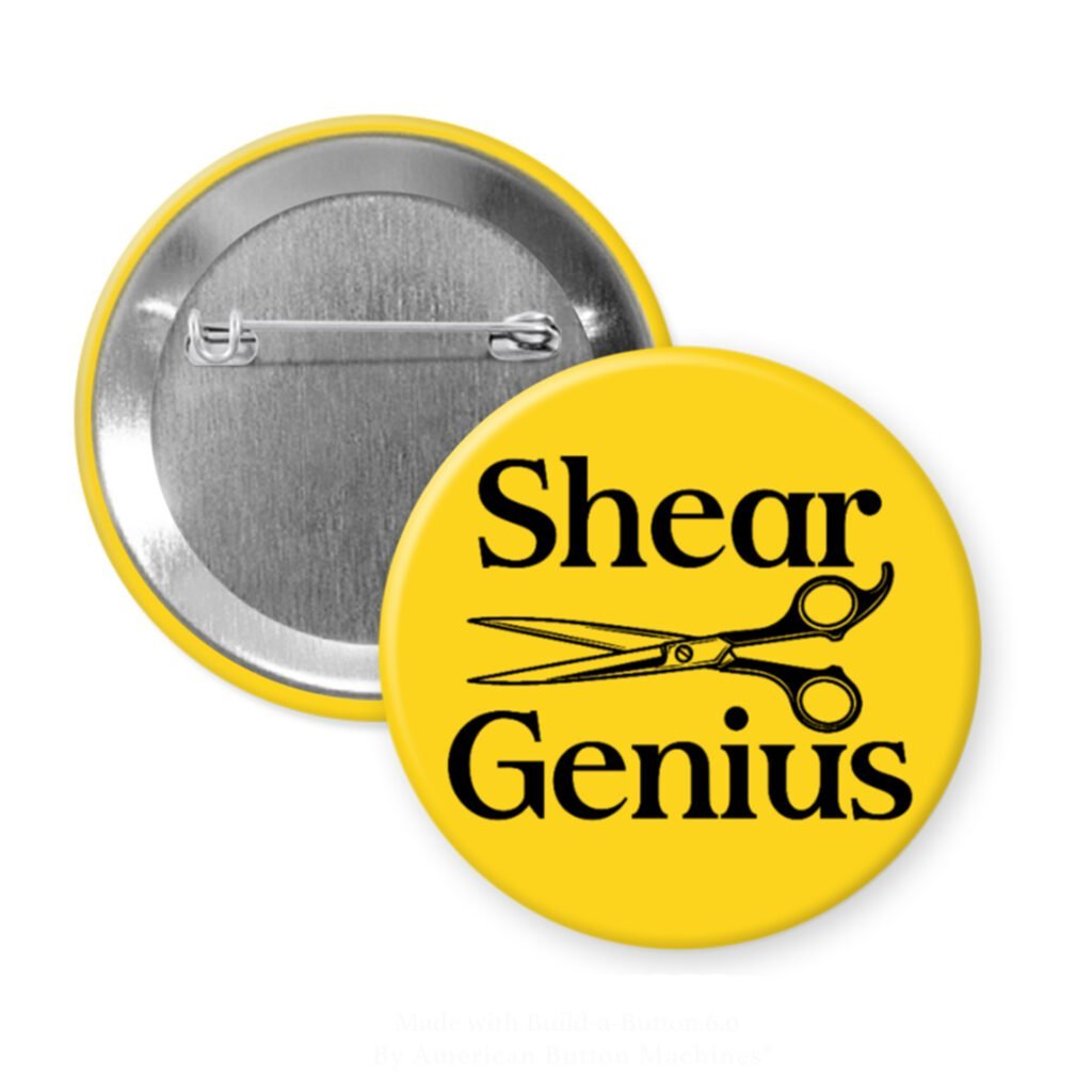 Yellow pinback button with an image of haircutting shears and the text 'Shear Genius' printed in black.