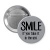 Grey pinback button with the text 'SMILE if you take it in the ass' printed in black.