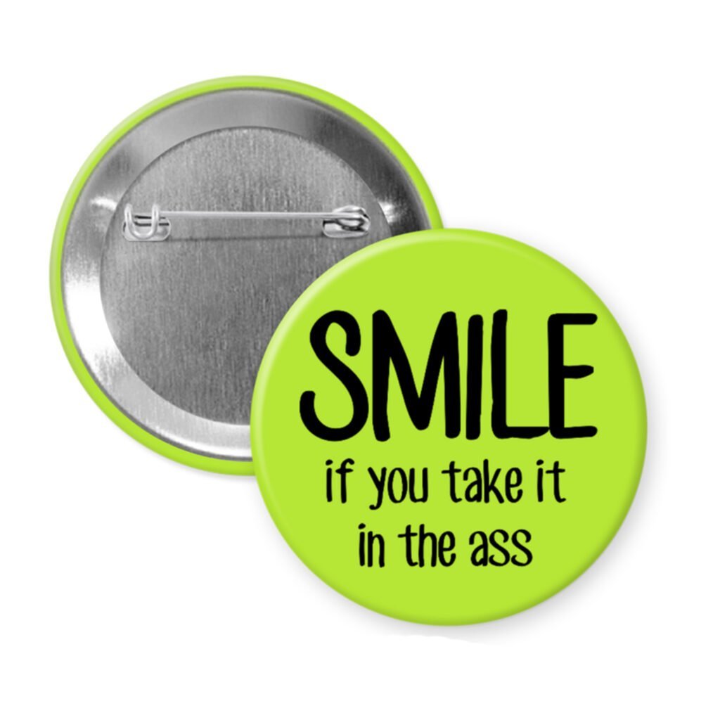 Green pinback button with the text 'SMILE if you take it in the ass' printed in black.