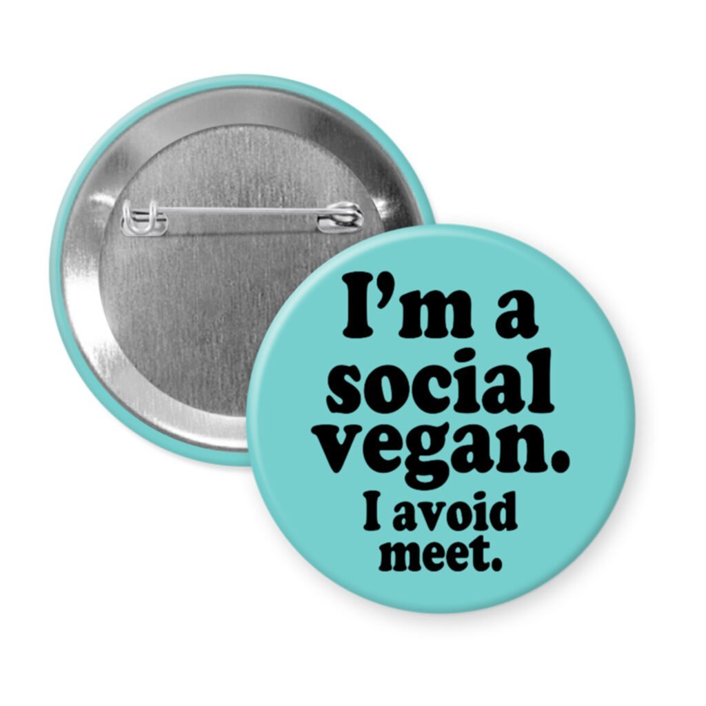 Blue pinback button with the text 'I'm a social vegan. I avoid meet.' printed in black.
